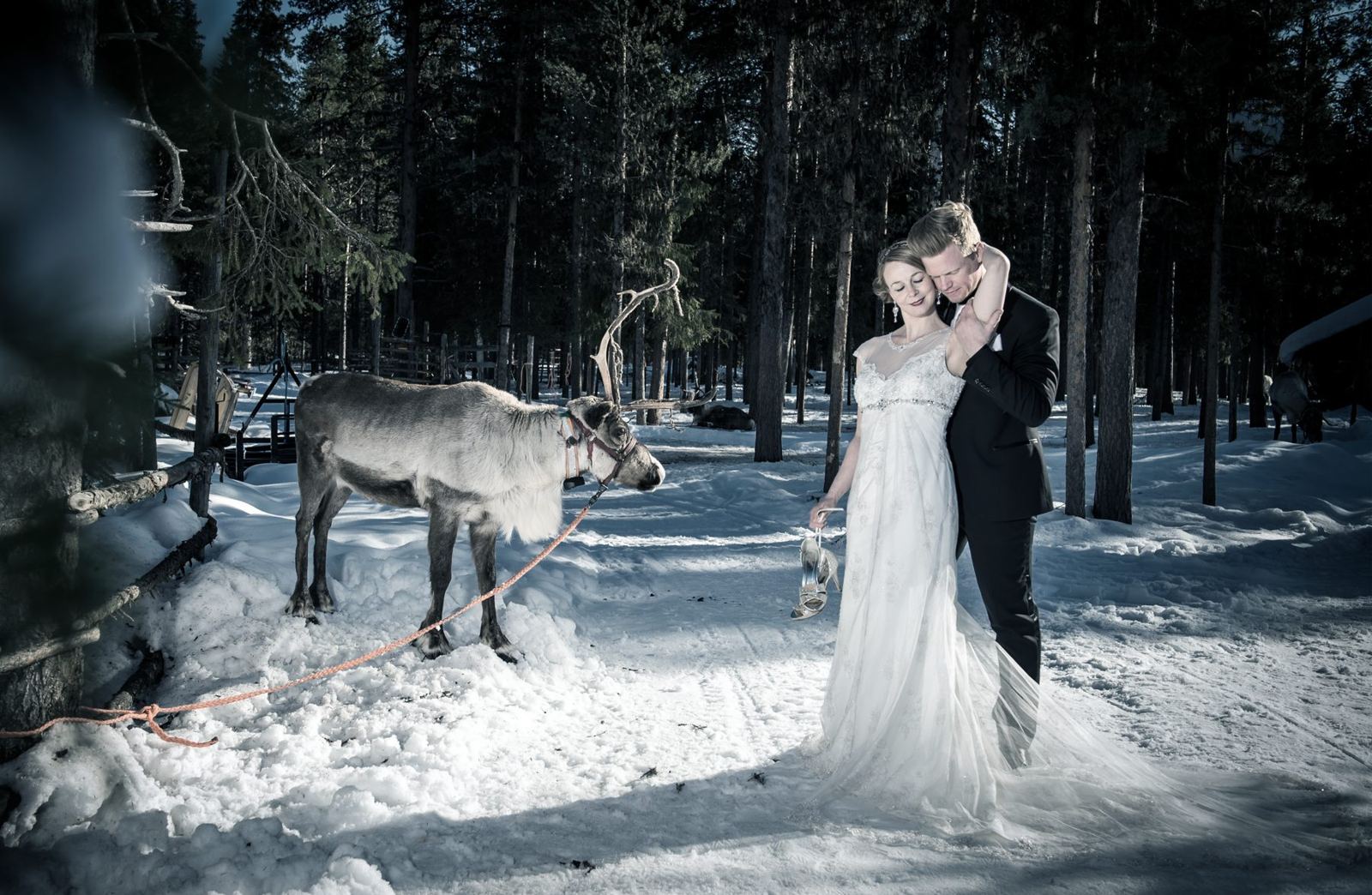Sigrid und Chris mit Rentier im verschneiten Wald in Finnland
