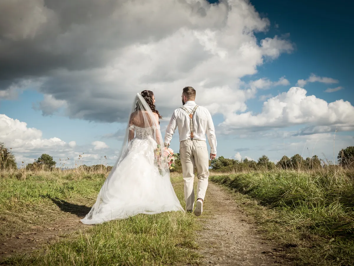 Brautpaar läuft Hand in Hand über den Feldweg – Hochzeit Celina & Sebastian in Rodgau