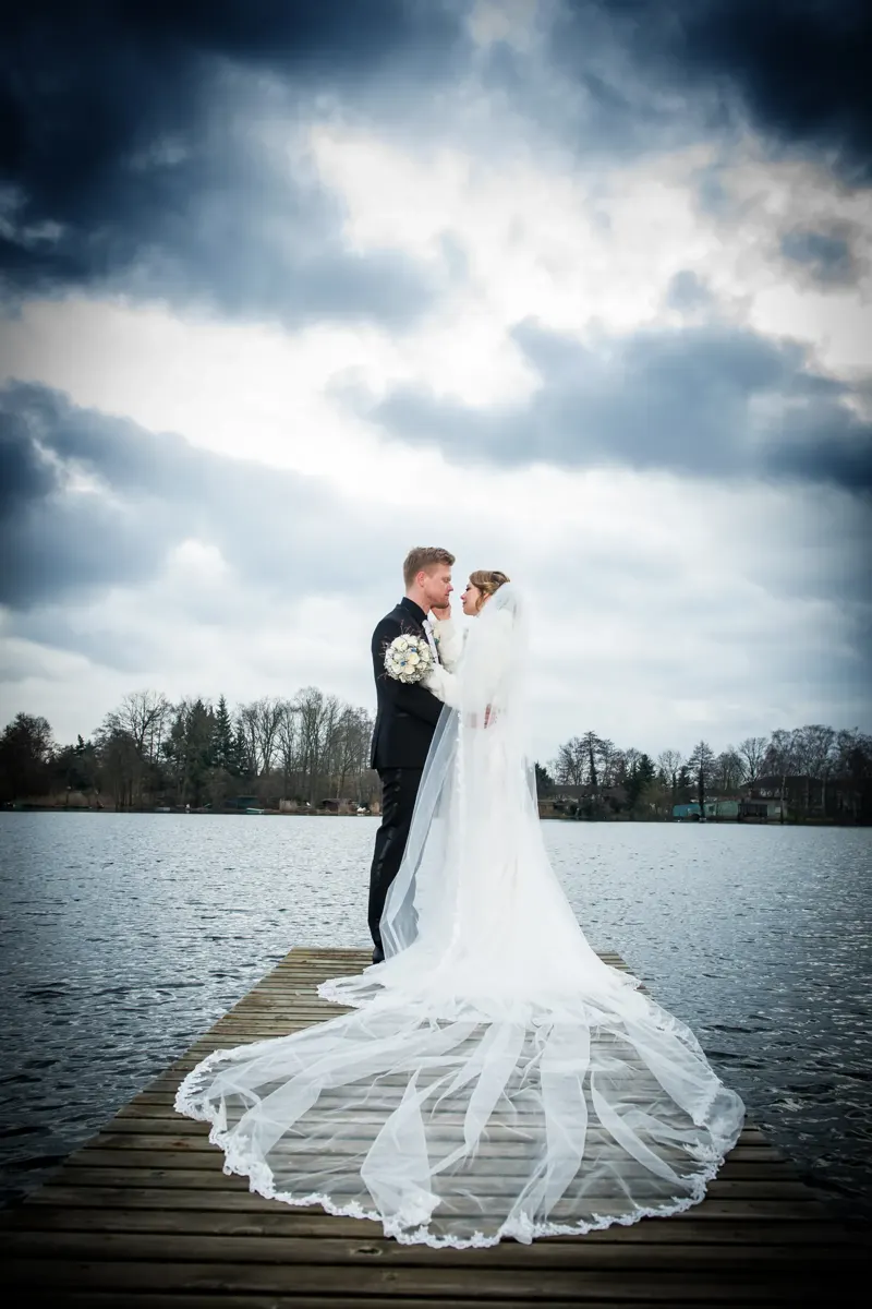 Braut mit langem Schleier am See – Hochzeit Sigrid & Chris bei der Winterhochzeit