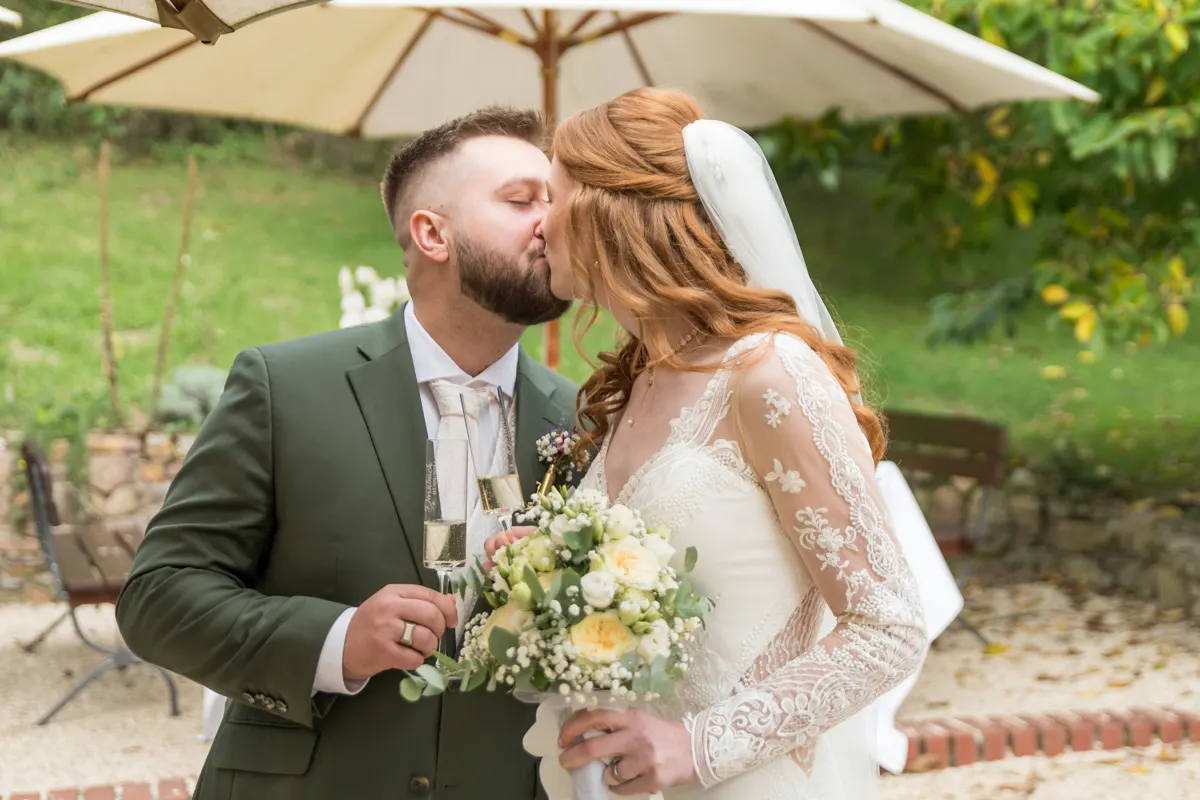Kuss beim Sektempfang – Hochzeit Vanessa & Dennis